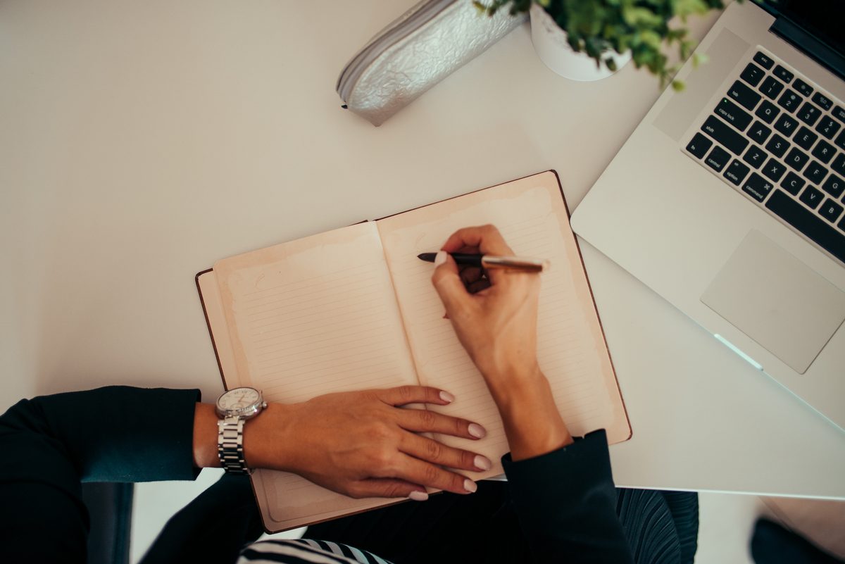 how to write product description for amazon india - drafting product description notes beside a laptop 2026